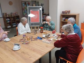 Bibliotekarka rozmawia na spotkaniu DKK z gośćmi.