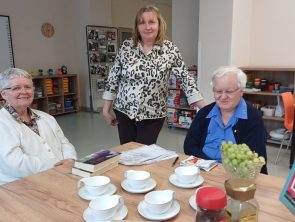 Bibliotekarka z czytelniczkami na kwietniowym spotkaniu DKK w bibliotece.