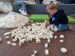 Dziecko z klocków LEGO Duplo buduje ratusz.