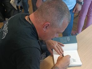 Łukasz Orbitowski podpisujący książkę