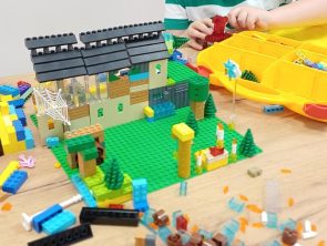 Chłopiec buduje z klocków lego makietę o tematyce Czarnoksiężnika z Krainy Oz