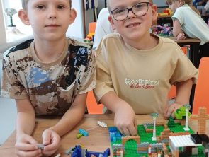 Dzieci budują z klocków lego gdzie tematem był Czarnoksiężnik z Krainy Oz