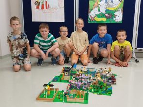 Pan razem z dziećmi budują z klocków lego gdzie tematem był Czarnoksiężnik z Krainy Oz