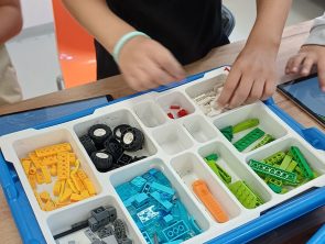 dzieci budują model pojazdu z klocków