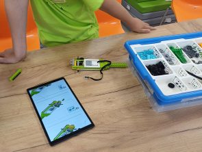 dzieci budują model pojazdu według instrukcji na tablecie