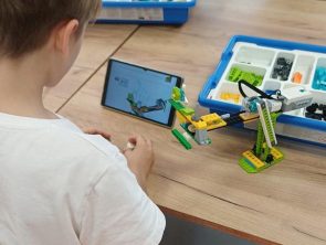 Chłopiec buduje model robota przy pomocy tabletu