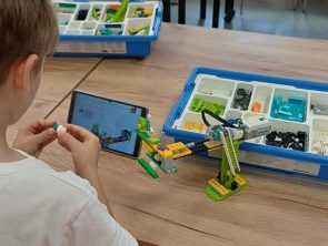 Chłopiec buduje model robota przy pomocy tabletu