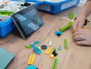 dzieci budują model pojazdu z klocków