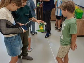 Prowadzący zajęcia i dzieci podczas budowy robotów