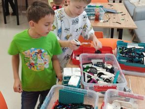 Chłopcy wybierają części z pojemnika