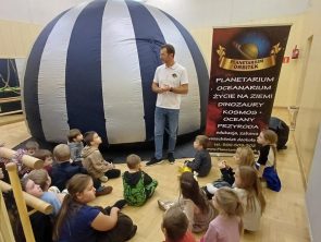 Pan stoi obok mobilnego planetarium