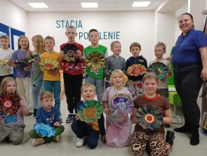 Pani prowadząca warsztaty razem z dziećmi prezentują swoje prace