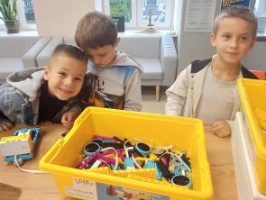 dzieci budują roboty z klocków