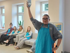 Uczestniczka warsztatów trzyma butelkę z ciekłym azotem