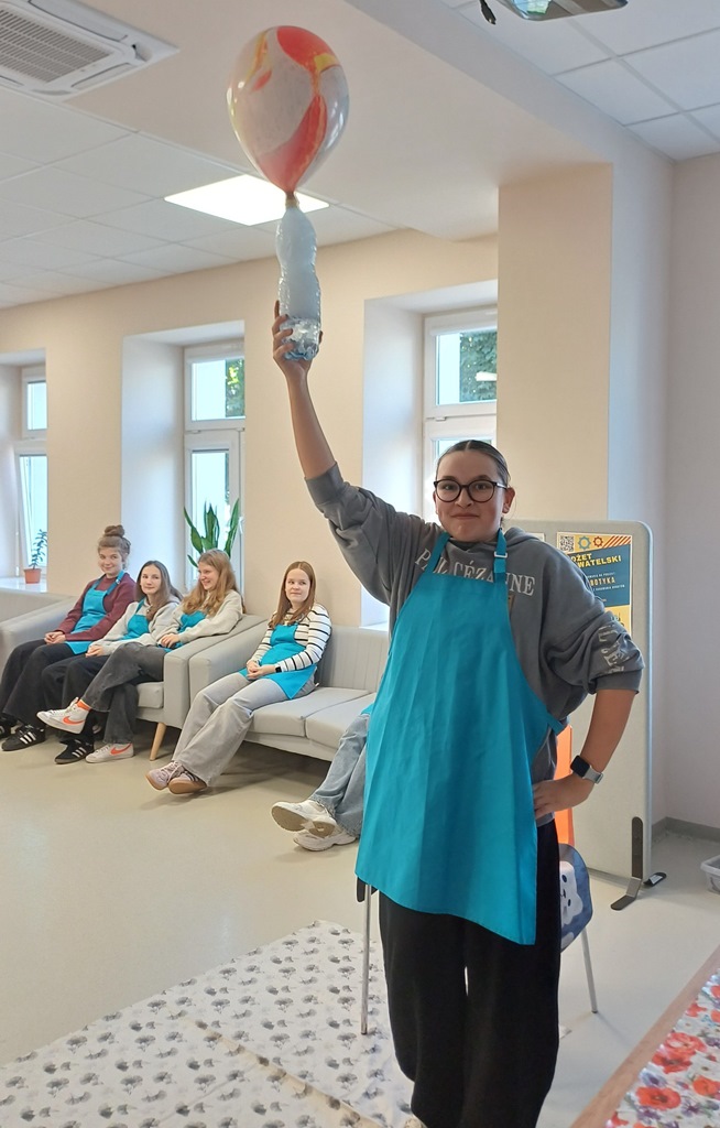 Uczestniczka warsztatów trzyma butelkę z ciekłym azotem