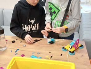 Chłopcy budują robota z klocków