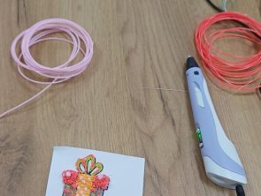 Na stole leży kartka z ozdobną grafiką