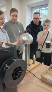 uczestnicy eksperymentują z generatorem van de Graaffa