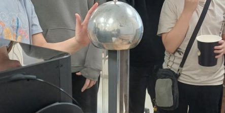 uczestnicy eksperymentują z generatorem van de Graaffa