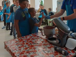 Prowadzący podaje dziecku własnoręcznie zrobione lody sorbetowe