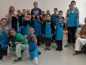 Wspólne zdjęcie opiekunów z dziećmi na zajęciach kuchni molekularnej