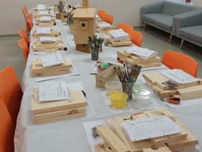 Na stole znajdują się materiały do budowy budek lęgowych